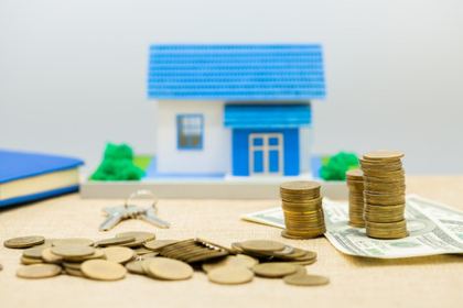 Stacks of coins and a small blue house