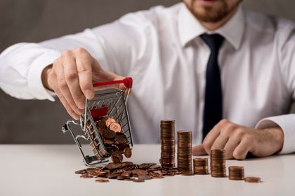 Man pouring coins from a small cart