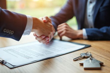 Handshake over a document with house keys