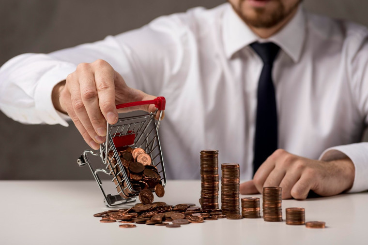 Man pouring coins from a small cart