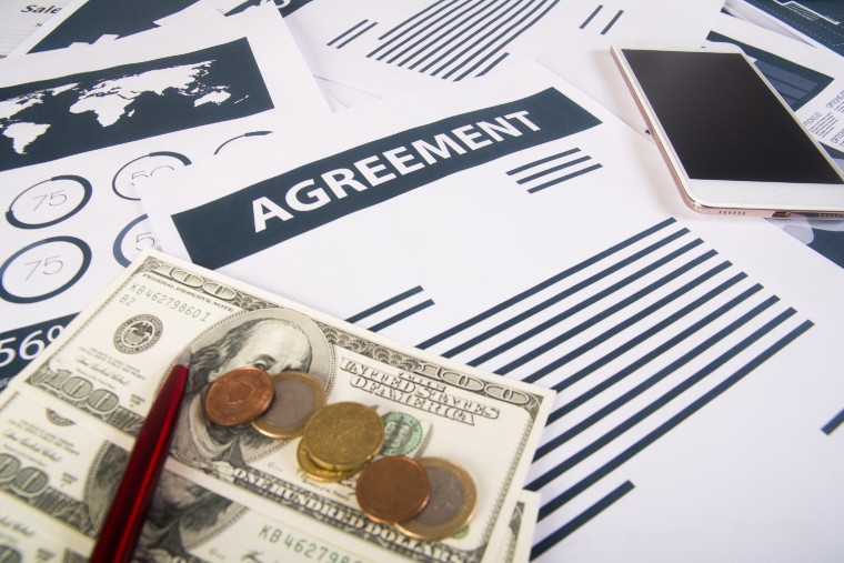 Agreement documents with cash and a pen